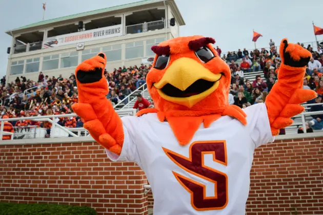 A vibrant orange bird mascot embodies the spirit of athletics, wearing a white jersey with an 