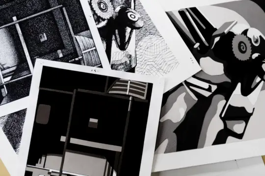 A collection of abstract black and white art prints, echoing art history's influence, are scattered on a surface. The designs feature geometric shapes, patterns, and abstract figures, each with a distinct bold style.