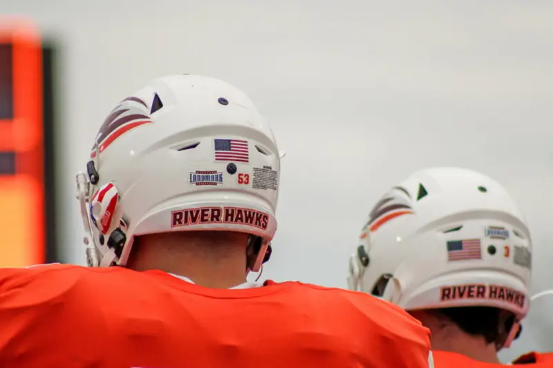 Two American football players in orange jerseys and white helmets with 