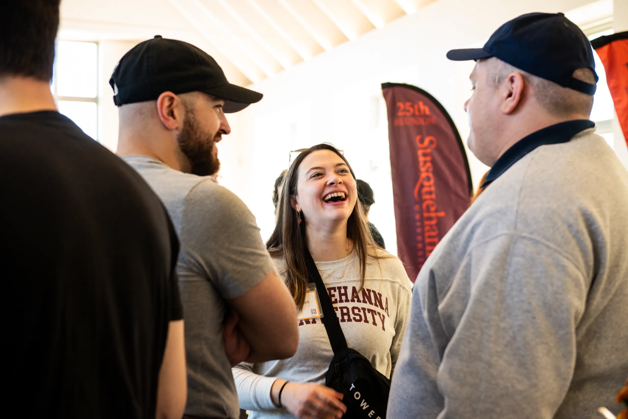 Three people gather indoors, engaged in a lively conversation. A woman wearing a 