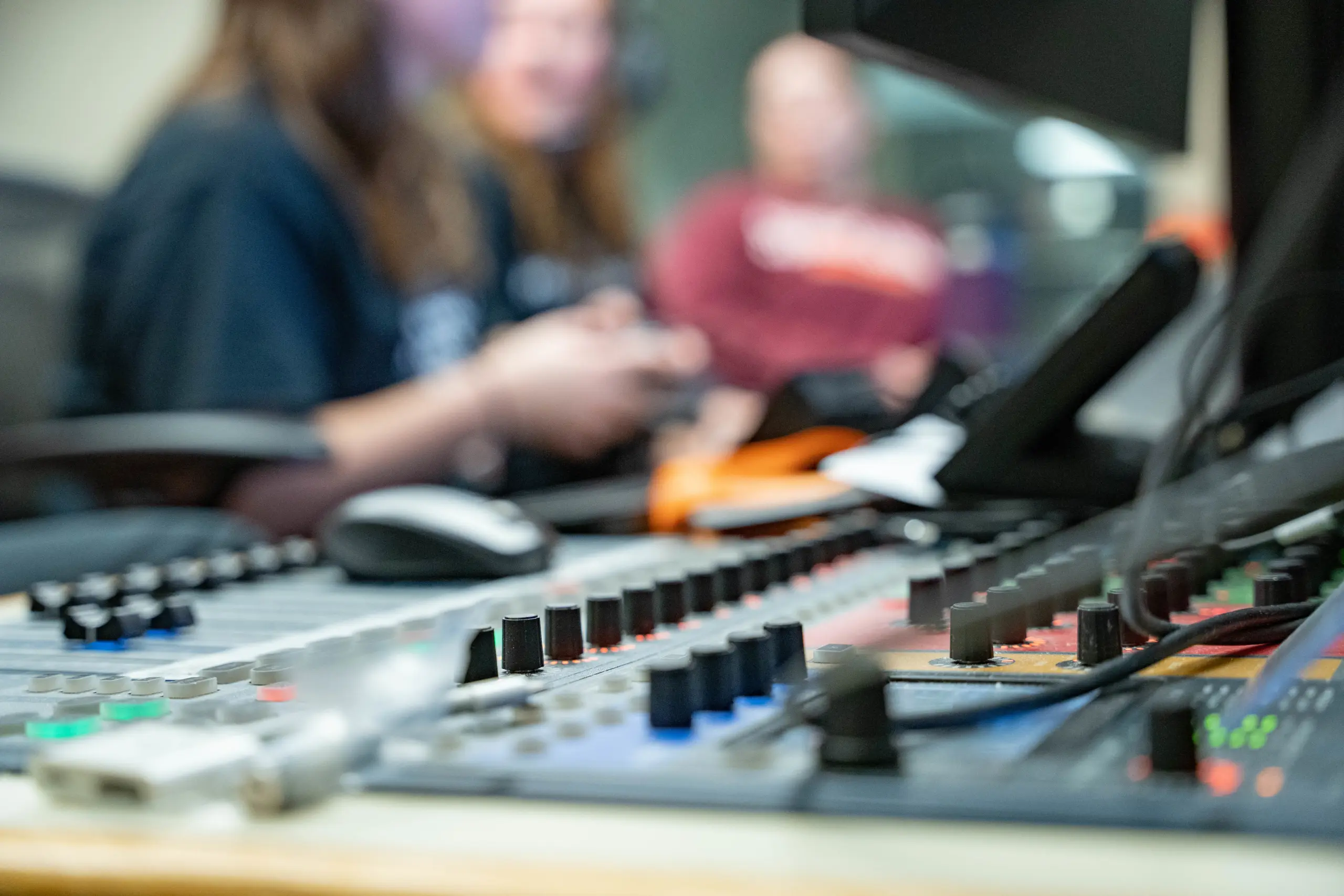 Close-up of a mixing console with various switches and knobs in focus, embodying a 