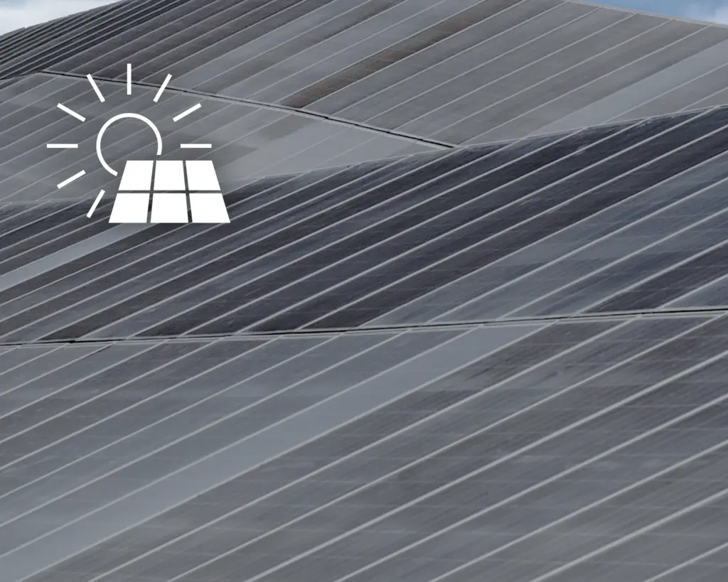 Rows of solar panels covering a large surface, with a white icon of a sun shining on a solar panel overlaid in the top left corner, highlighting details about clean energy solutions.