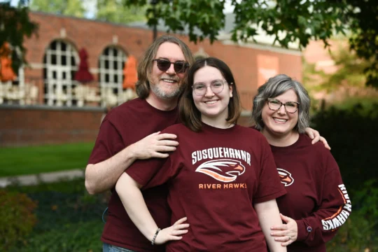 Three people wearing matching maroon 