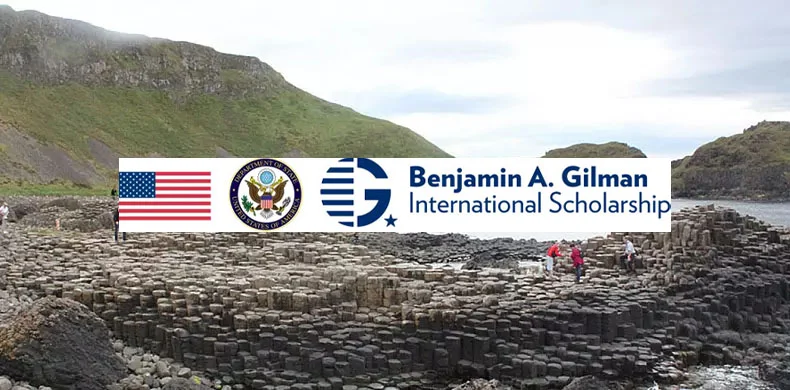 People walk on the hexagonal basalt columns at Giant’s Causeway, with the Benjamin A. Gilman International Scholarship logo and the U.S. flag superimposed over the landscape.