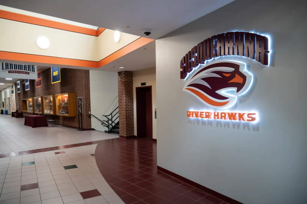 A brightly lit hallway showcases the 体育买球 River Hawks logo and display cases, reflecting recent Campus Transformations that enhance school pride and modernize the university environment.