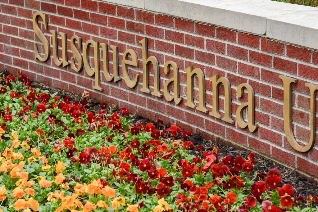 Gold letters on a red brick wall spell 