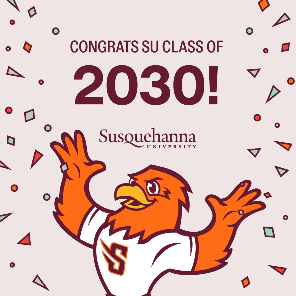 An orange bird mascot wearing a white shirt with an 